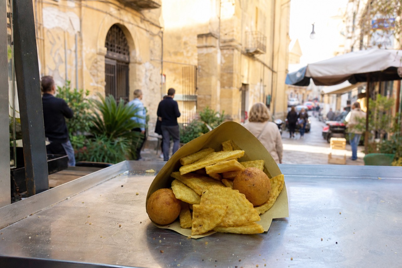 Arancine and panelle stacked at a Palermo street food counter