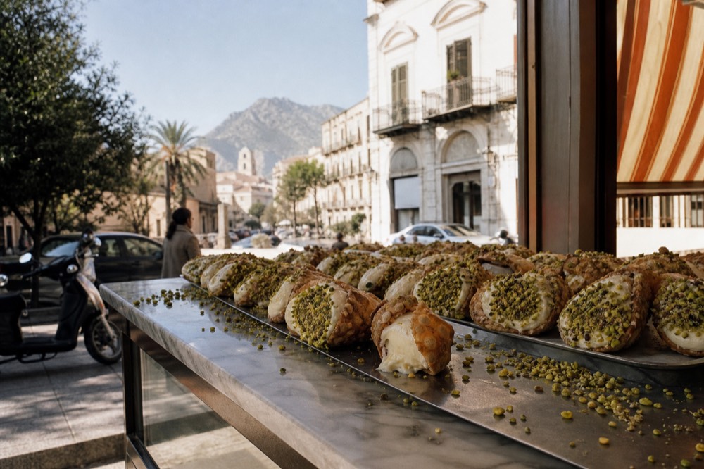 Cannoli shells filled with ricotta cream arranged on a pastry counter