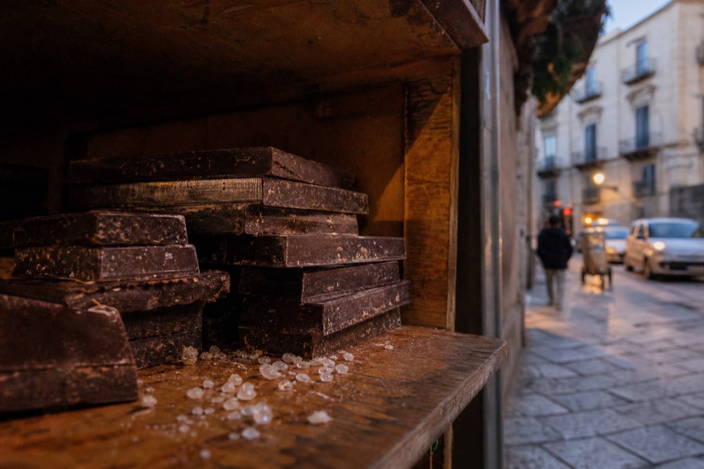 Bars of Modica chocolate stacked on a wooden shop shelf