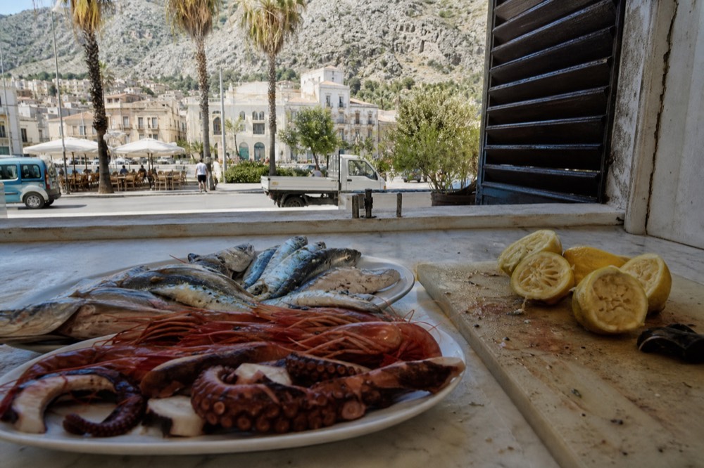 Fresh seafood platter on a marble counter in a Palermo trattoria