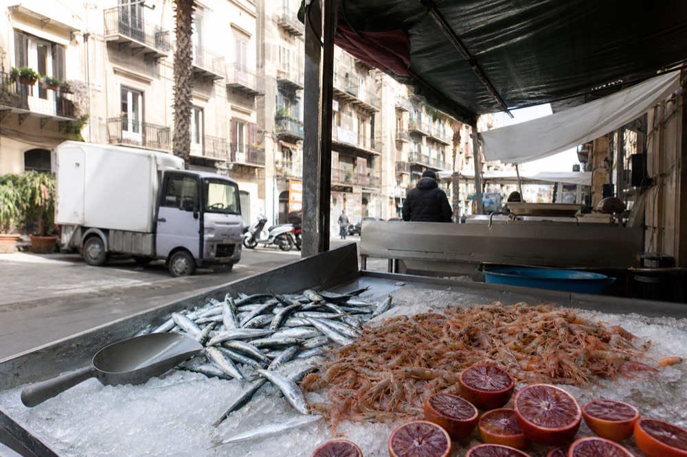 Fresh seafood and citrus arranged on a market stall counter