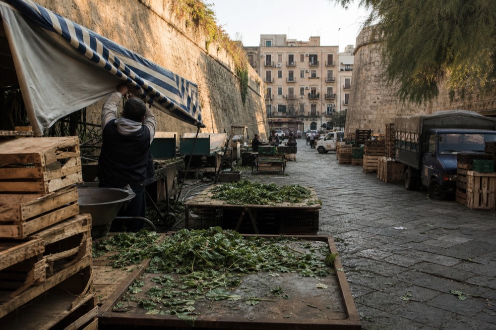 Ballarò market lane in late afternoon with stalls closing and empty ground between them