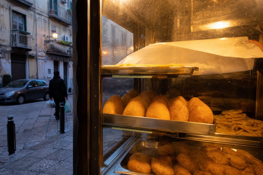 Arancine, panelle and crocchè arranged in a fry shop display case