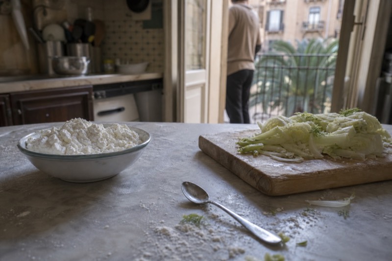Chopped vegetables, flour and fresh ricotta laid out on a home kitchen bench in Sicily.