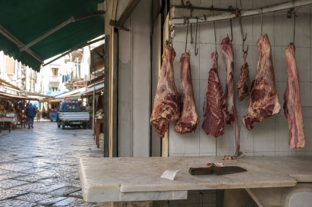 A butcher's stall in the Capo market with meat hanging outside