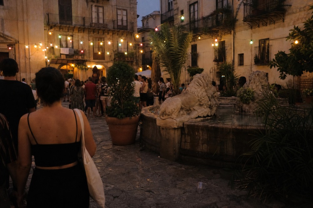 Evening crowds and decorative lights in a Palermo square during a festival