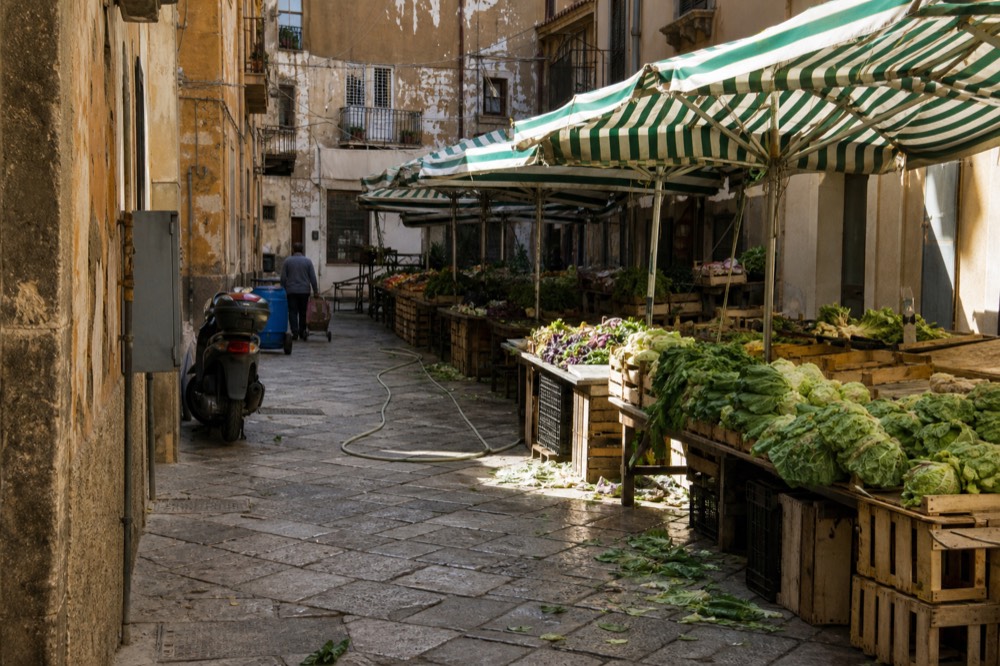 Striped market awnings along a Palermo street in morning light