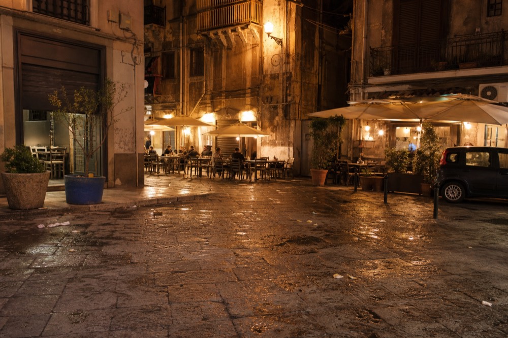 Lit bar terraces around an empty square in the Vucciria at night