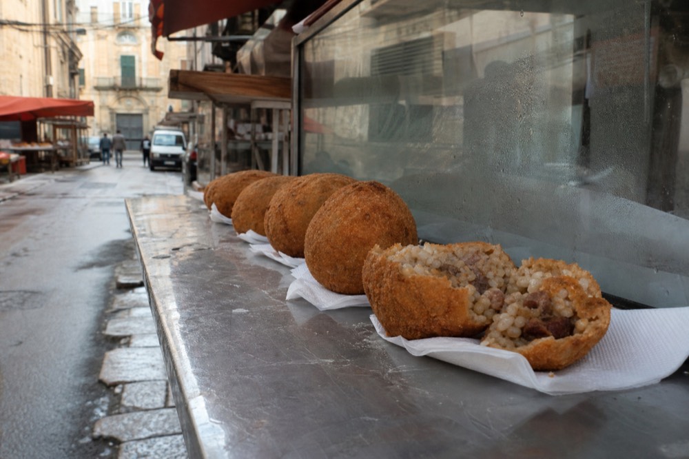 Round fried rice balls with meat filling arranged on a counter