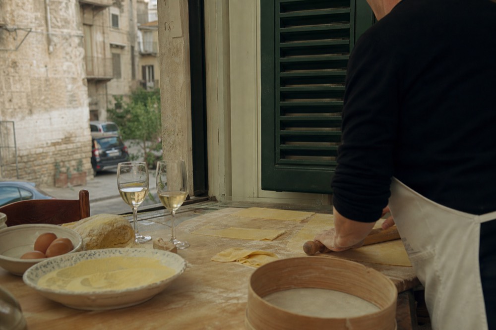 A hands-on cooking class table with fresh pasta ingredients and wine glasses