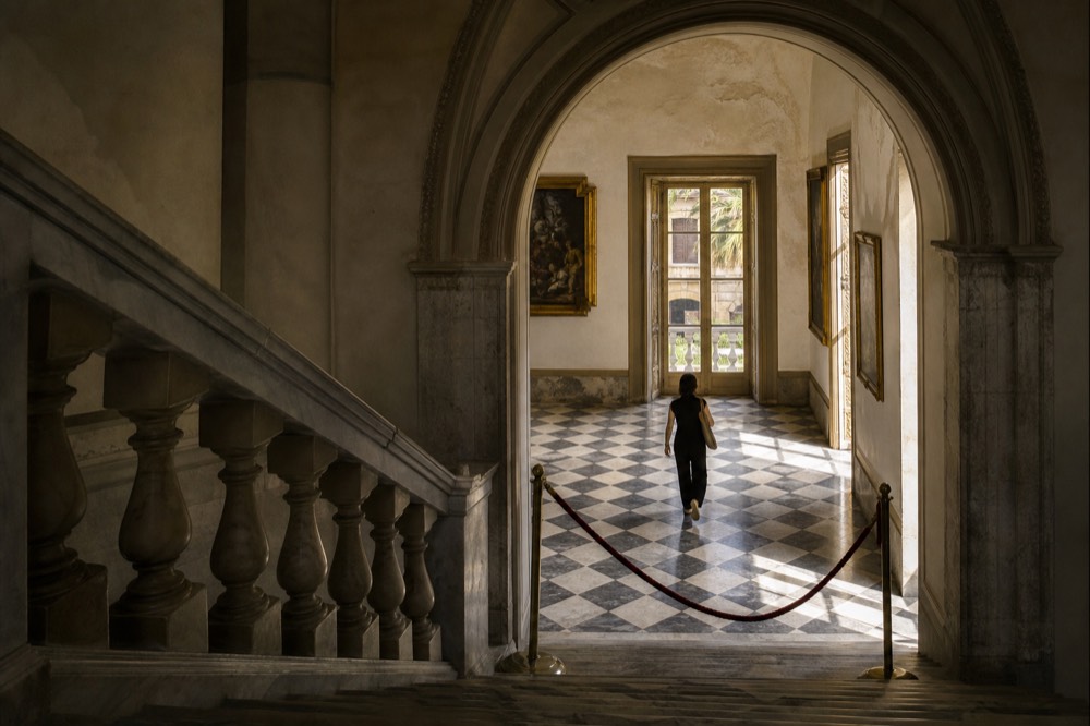 Grand arched hall of a historic palace with paintings on the walls